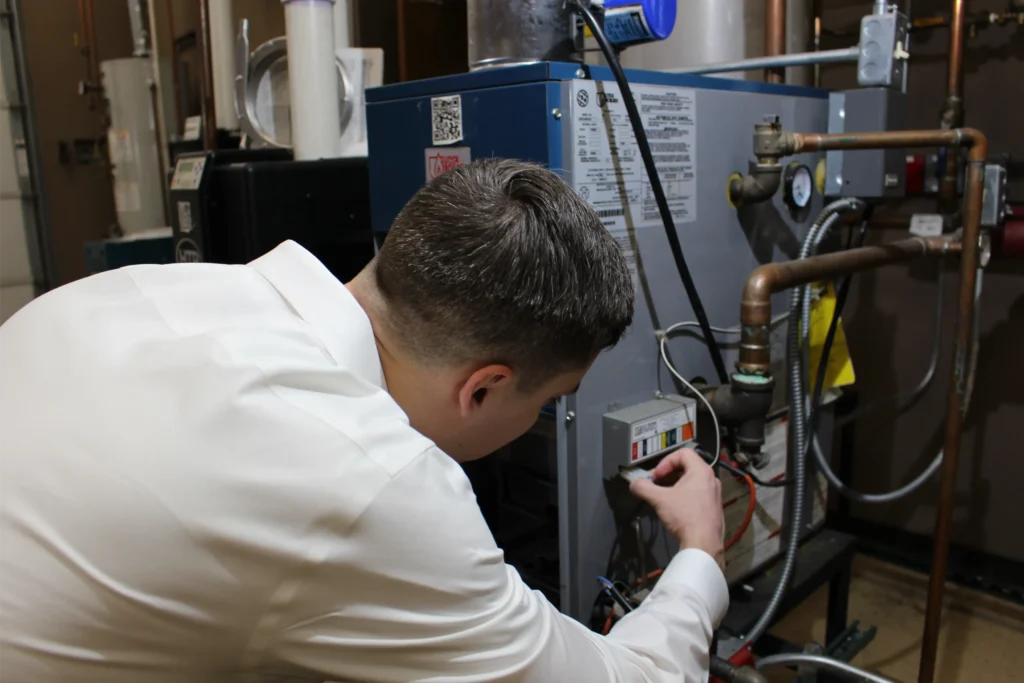 HVAC technician inspecting and servicing a commercial heating system to ensure safe and efficient operation.